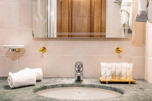 ein Bad mit einem Waschbecken und einem Spiegel in der Unterkunft Hotel Cristallo in Sestriere