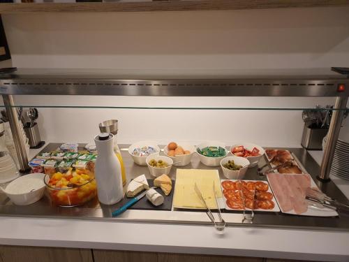 a counter with a bunch of food in a kitchen at ATOLON PARK HOTEL in Brumath