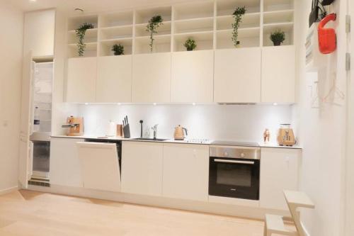 a white kitchen with white cabinets and a stove at Exquisite apartment, most convenient location, Apt 5. in Copenhagen