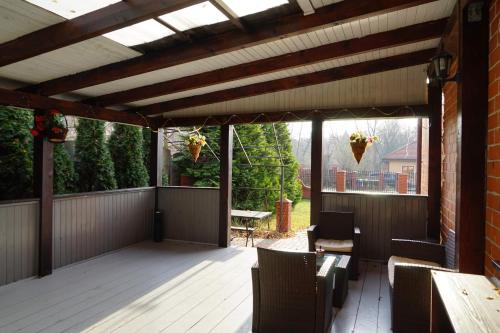 a patio with a wooden deck with chairs and a table at Dom Gościnny 8 km od Suntago, Deepspot in Radziejowice