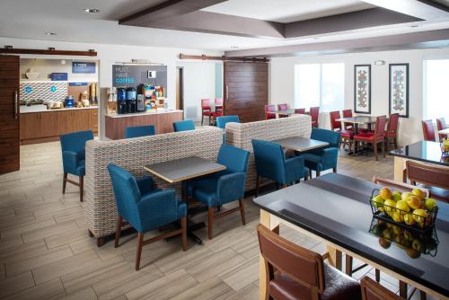 a restaurant with blue chairs and tables in a room at Holiday Inn Express & Suites Bellevue -Omaha Area- by IHG in Bellevue