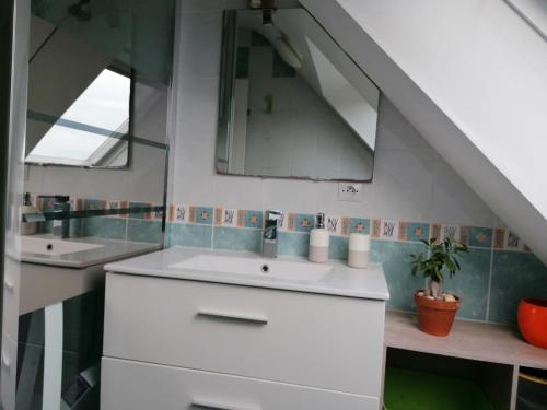 a bathroom with two sinks and a mirror at Chez Jak et Laurent in Quéven
