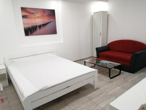 1 dormitorio con 1 cama y 1 silla roja en Airport view Apartment en Belgrado