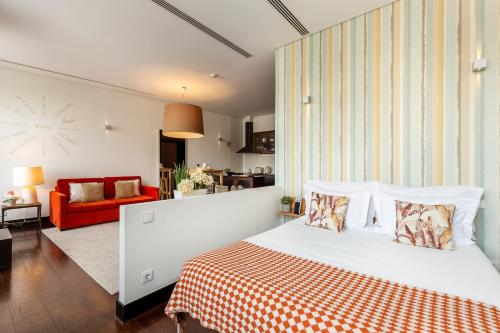 a bedroom with a bed and a red couch at YOUROPO - Torre in Porto