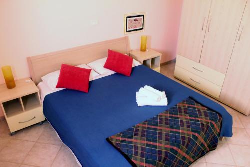 a bedroom with a blue bed with red pillows at Santa Maria flats in Santa Maria