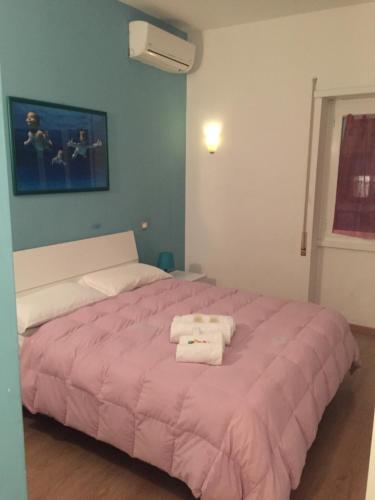a bedroom with a pink bed with towels on it at B&B SPQR in Rome