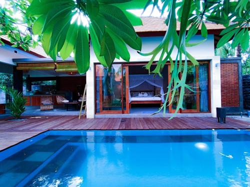 a house with a swimming pool in front of a house at Coco Garden Pool Villas in Kubutambahan
