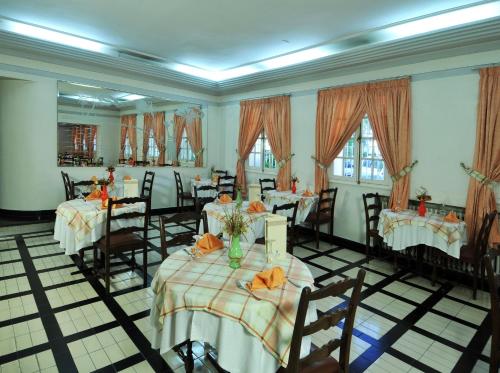 a dining room with tables and chairs and windows at Hotel Splendid in Fez