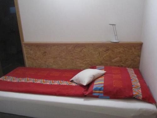 a bed with a red blanket and a lamp on it at Ferienwohnungen Fuchshuber in Neukirchen vorm Wald