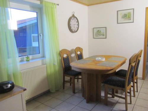 a dining room with a wooden table and chairs at Ferienwohnungen Fuchshuber in Neukirchen vorm Wald