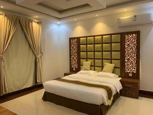 a bedroom with a large bed and a window at شقق حدائق الزيتون للوحدات السكنية -اقتصادية in Hail