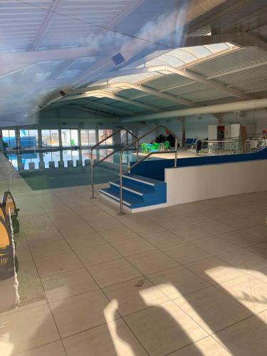 an empty building with blue stairs in the middle at 3 bed presitage caravan Doniford Bay in Watchet