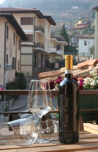トレモージネ・スル・ガルダにあるCasa Ciarìのグラスワインの横に置かれたワイン1本