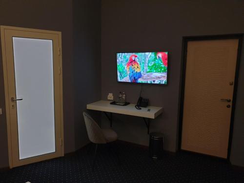 a room with a table and a tv on the wall at LEX Trend Hotel in Irpin'