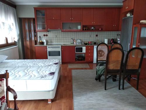una cocina con armarios rojos y una cama en una habitación en House in the Village en Fotolívos