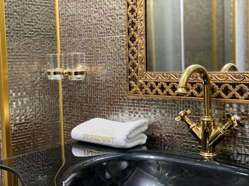 a bathroom with a sink and a mirror and towels at President Luxury in Ploieşti