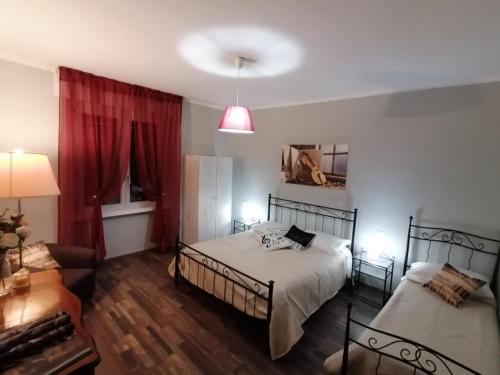 una camera con letto, divano e tende rosse di Segui le note della Tua vita a Cremona