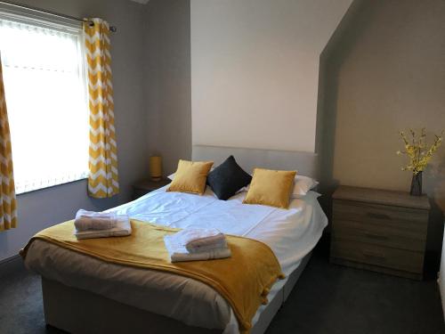 a bedroom with a bed with two towels on it at Jodon House in Middlesbrough