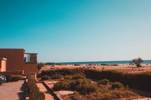 a view of a beach with a building and the ocean at Luxury Beach Apartment - Romantic Weekend Getaway in Imi Ouaddar