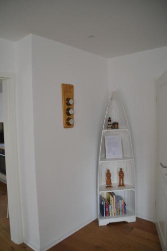 a book shelf in a corner of a room with a book shelfigunigunigun at Nordlichthuus in Tönning