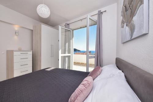 um quarto com uma cama e vista para o oceano em Apartman Luka em Igrane