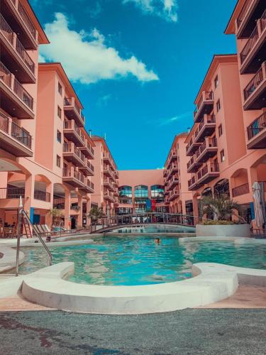 a swimming pool in the middle of two apartment buildings at Jurerê Beach Village - Flat na Praia in Florianópolis