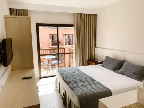 a hotel room with a bed and a balcony at Jurerê Beach Village - Flat na Praia in Florianópolis