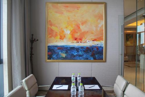 a dining room with a table and a painting at Crowne Plaza Yichang by IHG in Yichang