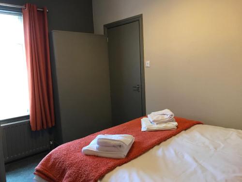 two towels on a bed with a red blanket at Jodon House in Middlesbrough