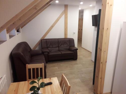 a living room with a couch and a table at Apartmány pod Mariánskými schody in Albrechtice v Jizerských horách