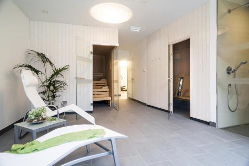 a bathroom with a shower and a chair in a room at IG City Apartments Danube Lodge in Vienna