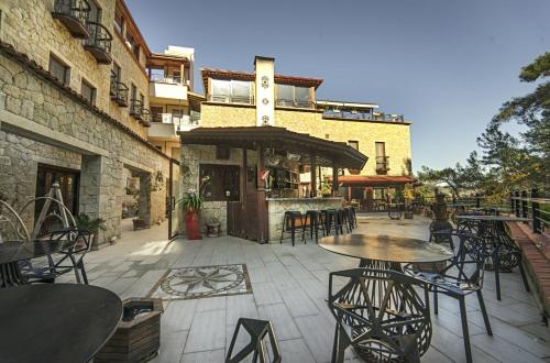 a patio with tables and chairs in front of a building at Kazdaglari Karye Müze Hotel in Kucukkuyu