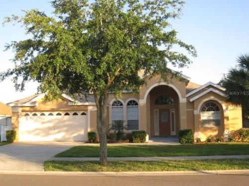a house with a tree in front of it at Family Vacation Home With Pool and Spa Near Disney and Universal in Orlando