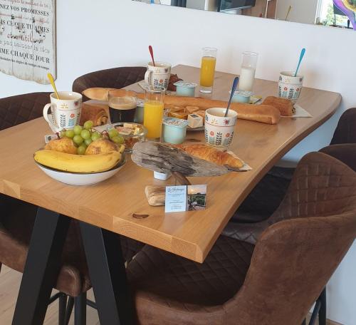 een houten tafel met veel eten erop bij Le bélouga in Sangatte