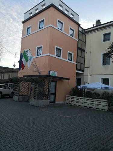 a large pink building with a flag on it at Hotel La Cantina in Alfonsine