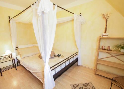 a bedroom with a bed with a canopy at Haus OstseeLicht in Sierksdorf