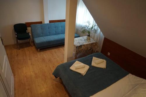 a bedroom with a blue bed and a blue couch at Dom Gościnny 8 km od Suntago, Deepspot in Radziejowice