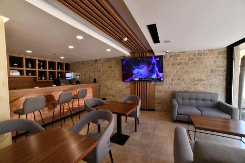 a restaurant with tables and a tv on a brick wall at HOTEL EMROVIC RAJ in Novi Pazar