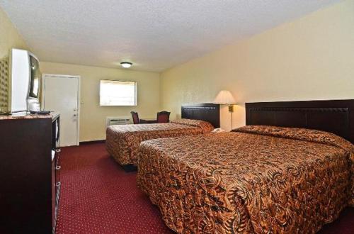 um quarto de hotel com duas camas e uma televisão de ecrã plano em Americas Best Value Inn Refugio em Refugio