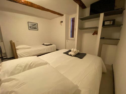 1 dormitorio con 2 camas y un osito de peluche en la parte superior en Hôtel Etape, en Les Omergues