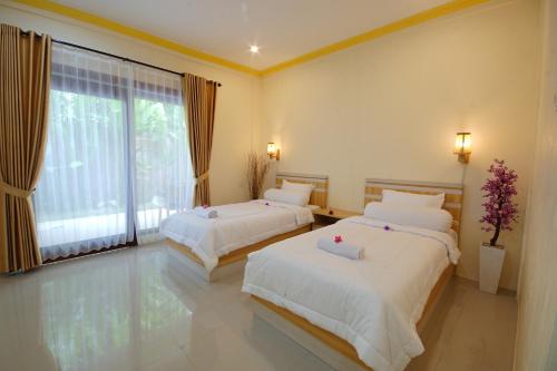1 dormitorio con 2 camas y ventana grande en Zamzam anjani villa en Praya