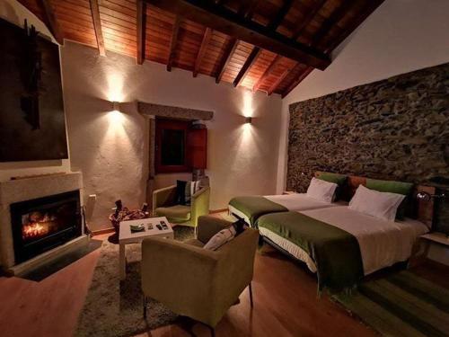 a bedroom with a large bed and a fireplace at Casa das Quintas in Quinta das Quebradas