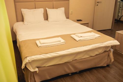 a bed in a room with two towels on it at Traveler's Mini-Hotel in Tyumen