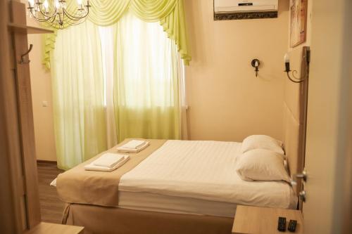 チュメニにあるTraveler's Mini-Hotelのベッドルーム1室(ベッド1台、タオル2枚付)