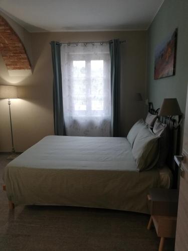 a bedroom with a large bed with a window at A cà ed Franca e Giaco in La Morra