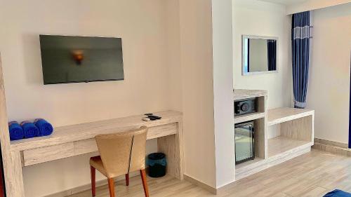 a room with a desk with a television and a chair at Kaani Palm Beach in Maafushi