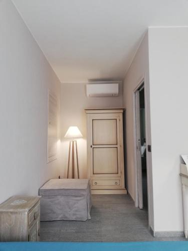 a white room with a bed and a lamp at A cà ed Franca e Giaco in La Morra
