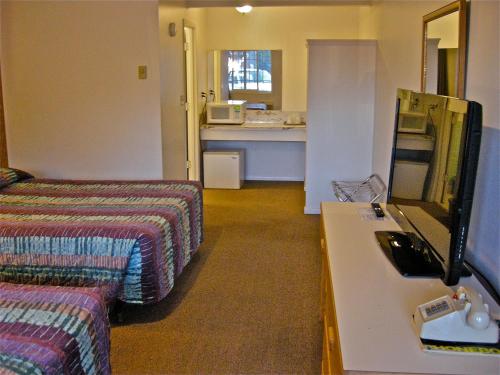 a hotel room with a bed and a desk at Motel 101 in Gold Beach