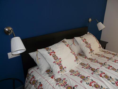 a bed with white sheets with flowers on it at Apartamento Rural Sorribos (VUT-CO-004306) in Muros