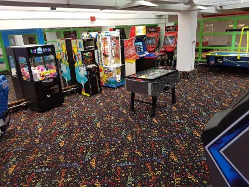 a room with several arcade games and a table at Crowne Plaza Kitchener-Waterloo by IHG in Kitchener